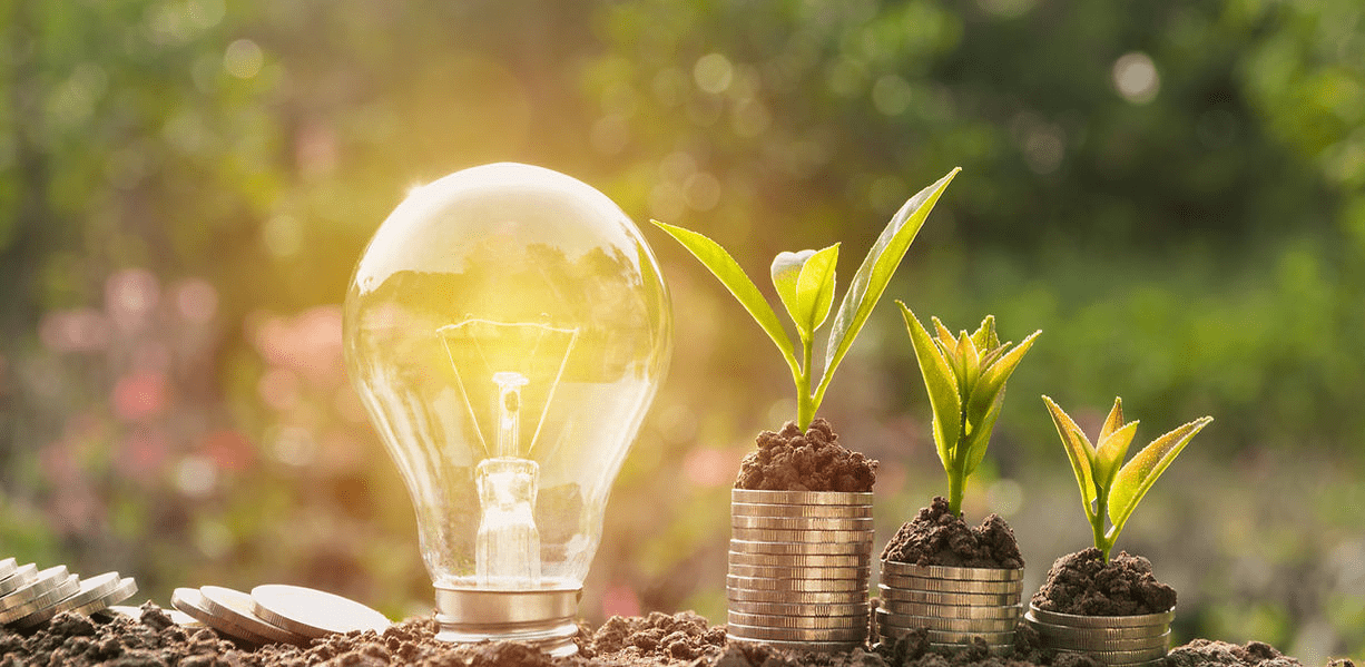 A light bulb sitting on top of some coins.