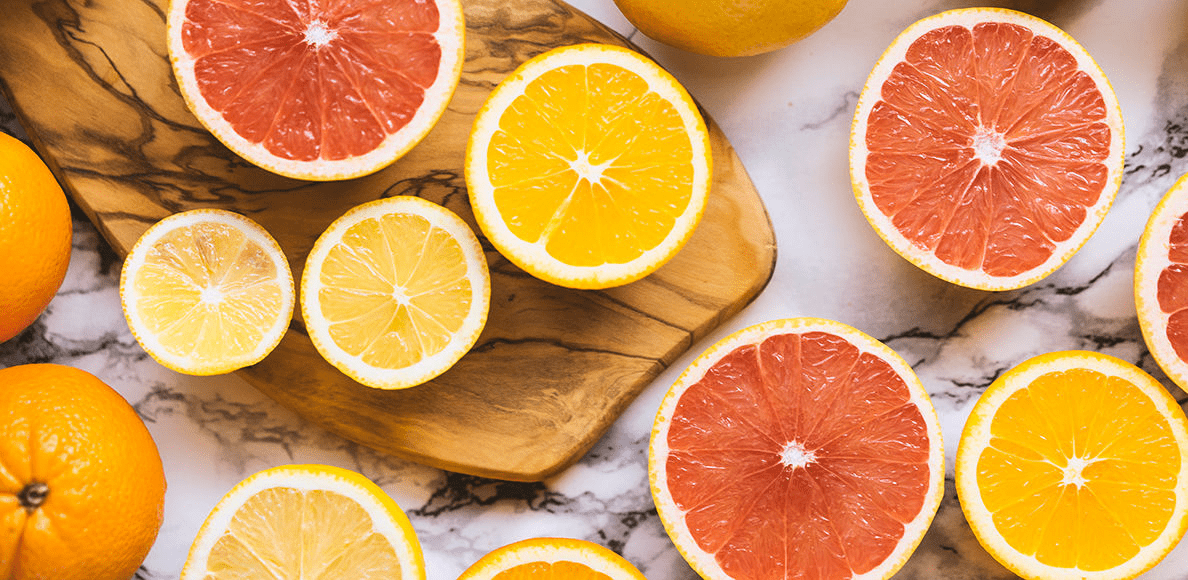 A cutting board with sliced up citrus fruits.