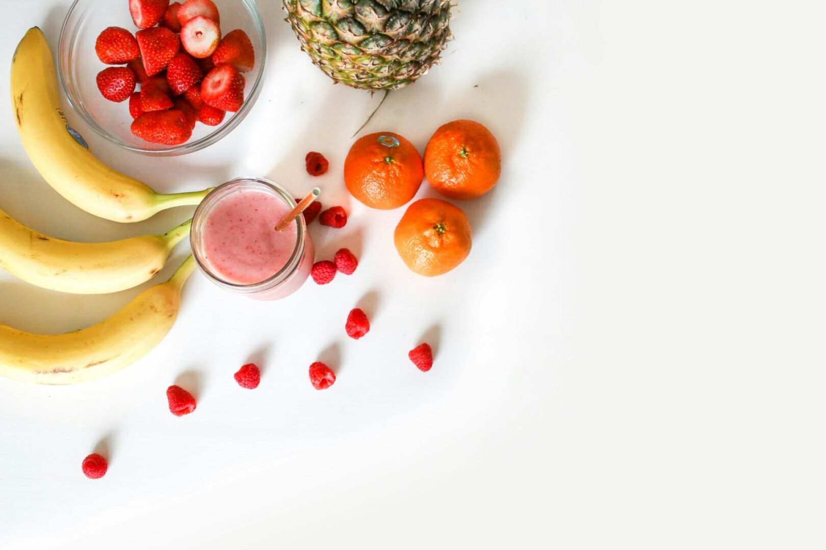 A table topped with fruit and a glass of juice.