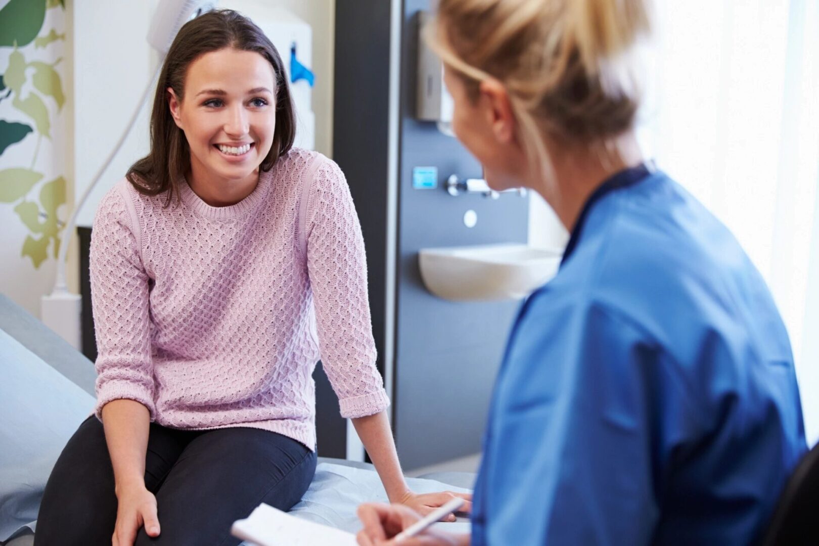 A woman sitting in front of a mirror talking to another person.